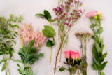 Different bunches of pink flowers lined up on a table