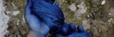 A person uses their blue-stained hands while working dyed blue fabric