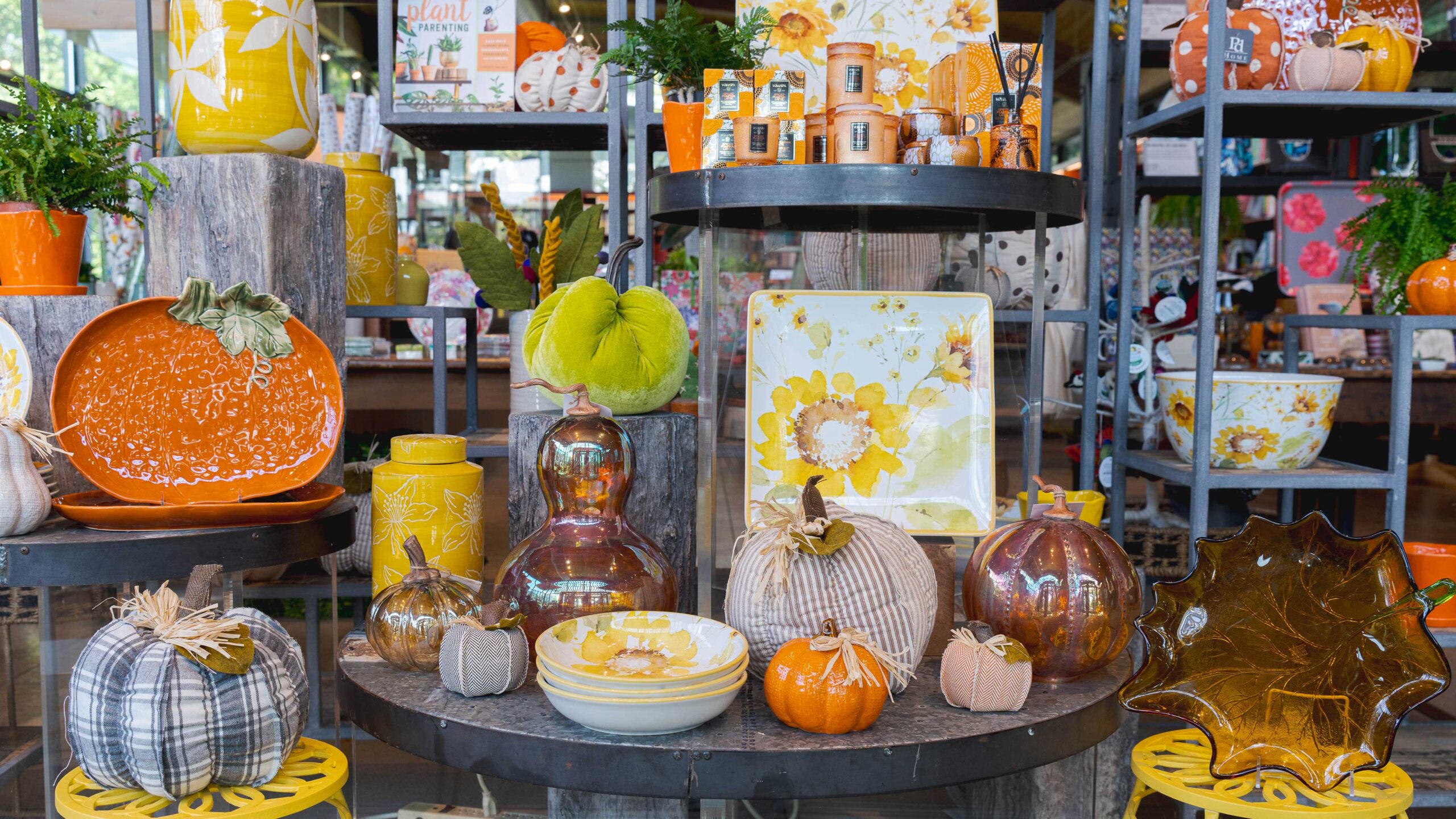 An arrangement of orange, black, green, and yellow Halloween goods and decor arranged on a shop table