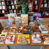a wooden table with a selection of books that focus on Hispanic/Latinx Heritage