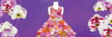 A dress fashioned from dozens of pink and red orchids against a purple backdrop