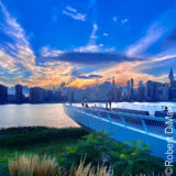 A waterside view of a city skyline at sunset