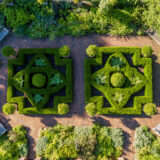 An aerial view of a decorative, garden with two symmetrical hedge designs.
