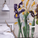 A bedside view of a wall mural depicting white, yellow, and purple iris flowers on long green stems