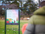 signage discussing the history of the Holiday Train Show on the Conservatory Lawn