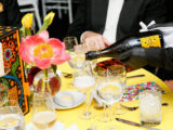 a person pours a bottle of champagne into a glass