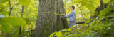 Photo of a scientist measuring the circumference of a tree in the forest
