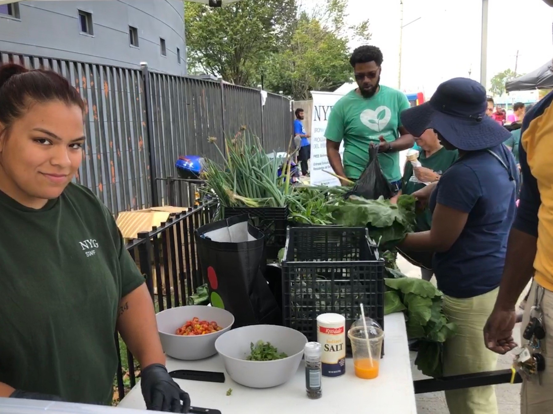 A person in a green shirt works with vegetables during a cooking demonstration