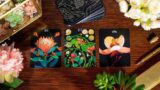 An arrangement of rectangular cards depicting colorful plants and flowers, arranged on a wooden table
