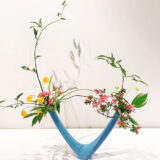 A contemporary flower arrangement in a blue vase