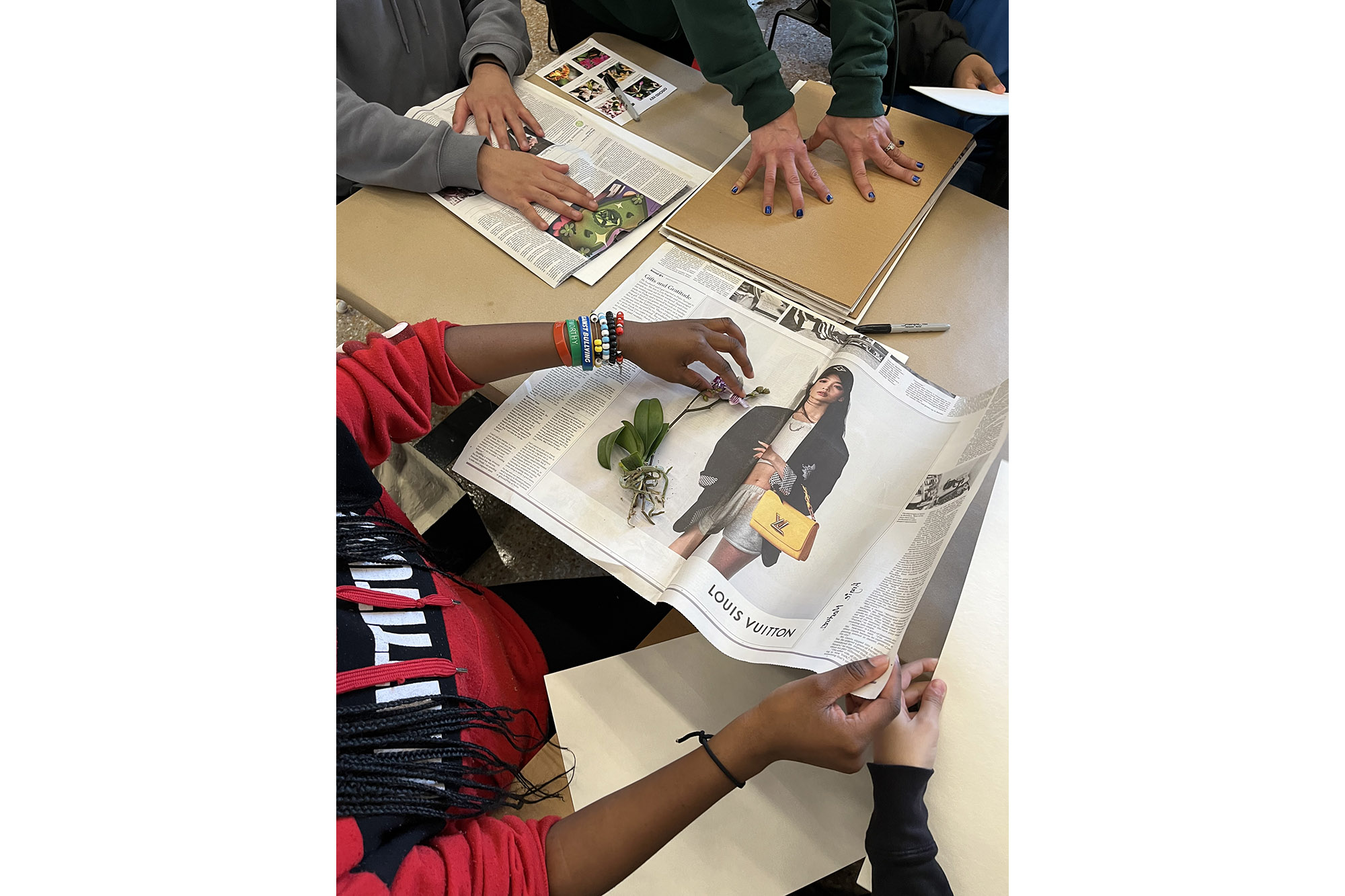 Students make herbarium specimens by pressing them on newspaper