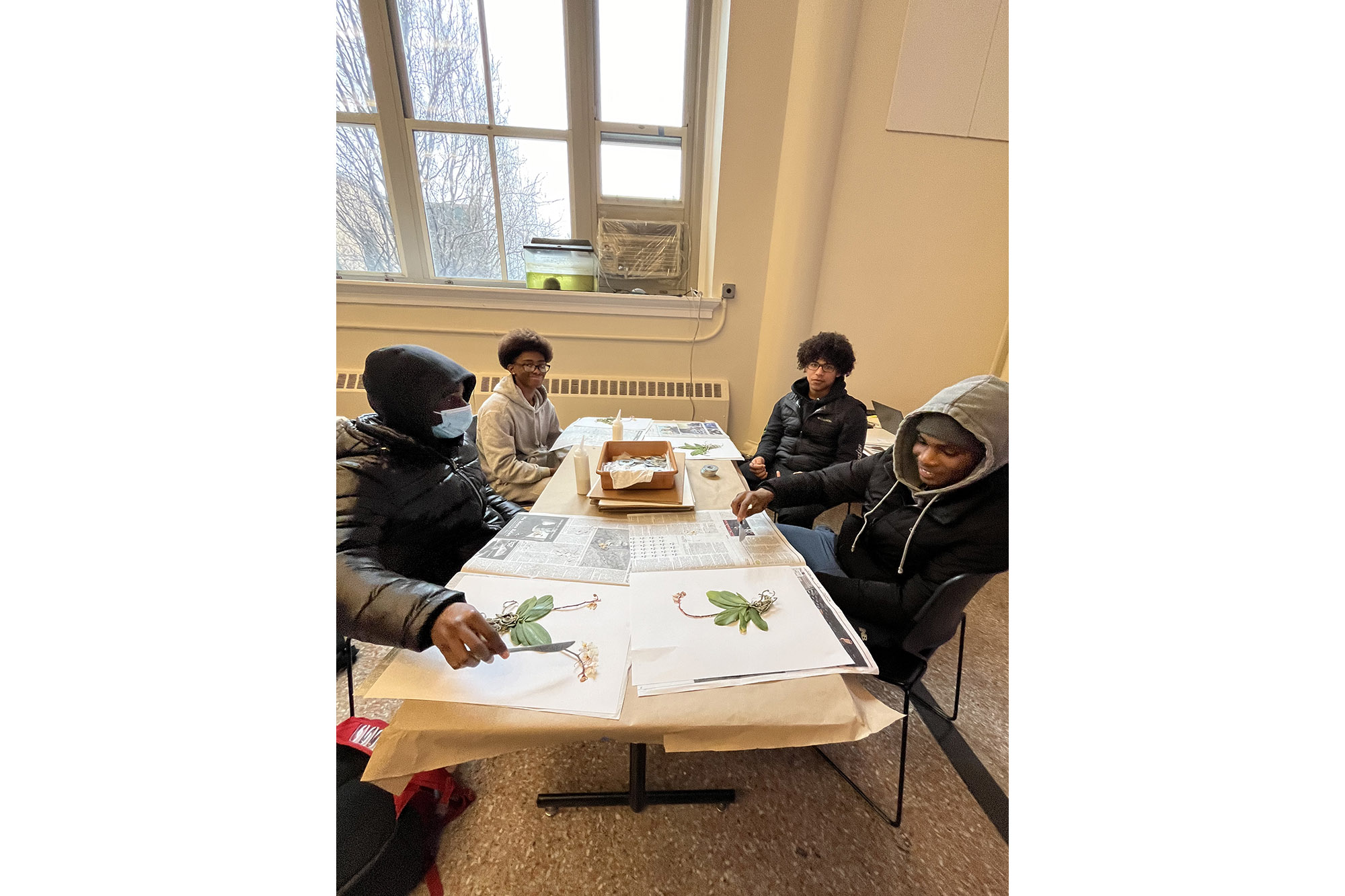 Students converse while taking part in a workshop around a table