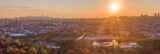 A golden aerial image with a sun setting and a vast overlook of New York City.