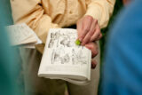 A person shares a black and white illustration in a book