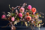 A bouquet of pink flowers against a dark backdrop