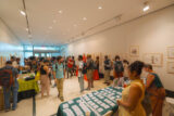 People walk around a room full of tables with information on programs and other green industry careers.
