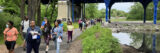 People walking on paved path along water