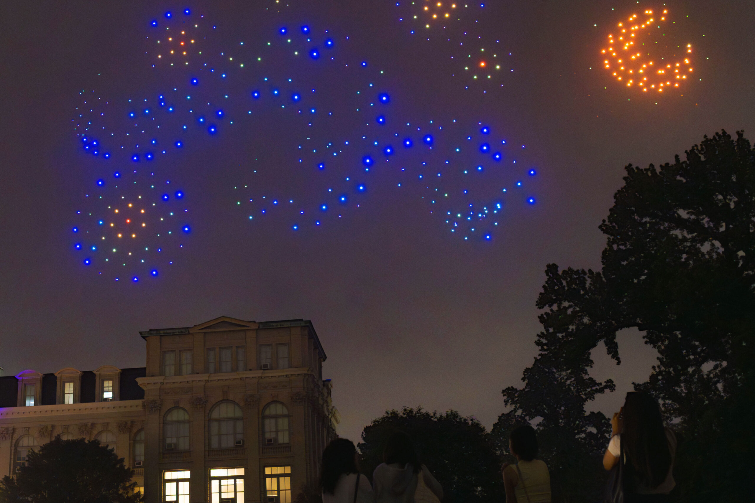 Blue and yellow lights fill the sky in the shape of swirls, stars, and the moon