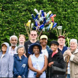 A group of people pose for a photo in a garden setting