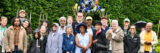 A group of people pose for a photo in a sunny garden