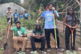People pose for a photo while working in a garden