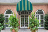 A green awning over large French doors