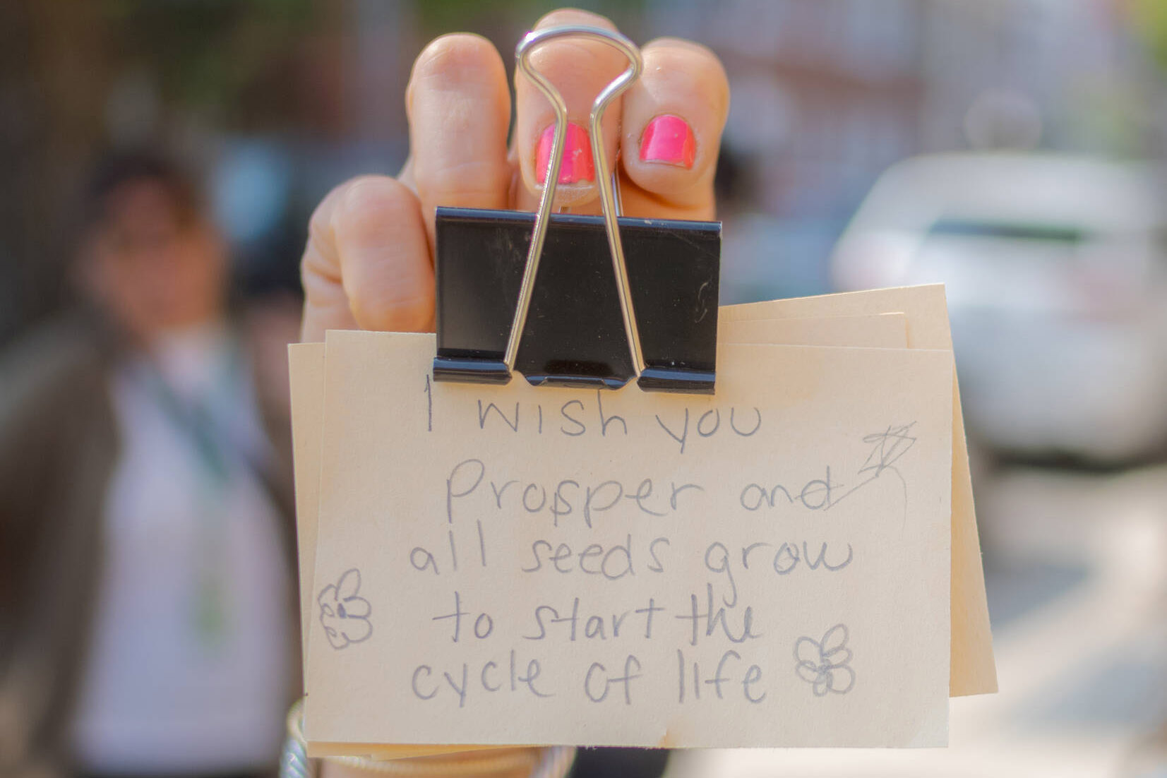 A person holds up a clipped deck of handwritten index cards