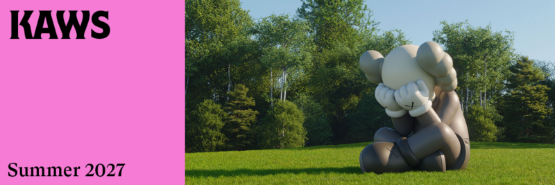 A sculpture of a large gray clown sitting in a sunny field with the word "KAWS"