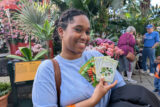 A person holds up a packet of seeds