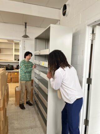 Two people setting up a file cabinet.
