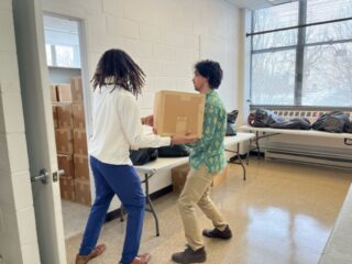 Two people carrying a box.