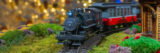 A model train travels through a twinkling miniature landscape