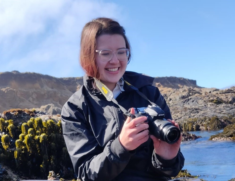 Smiling person with camera.