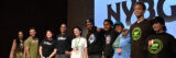 A group of people poses for a photo on a lecture stage