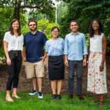 Five people pose outdoors for a photo