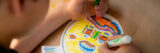 A child makes a mask with a paper plate and markers