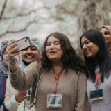 A group of students take a selfie outdoors during a class event