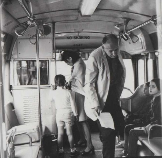 Parents and their children board a bus in this black and white photo
