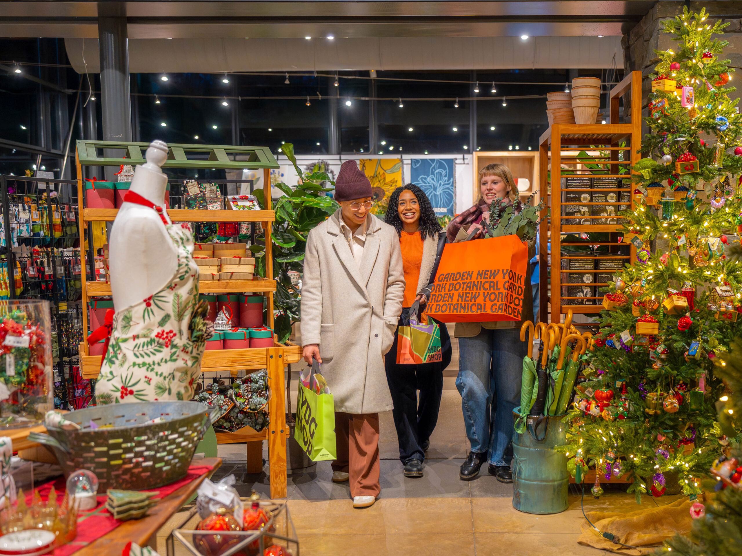 Three people shop in a warmly lit holiday store