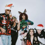 A group of partygoers wearing ugly sweaters and santa hats