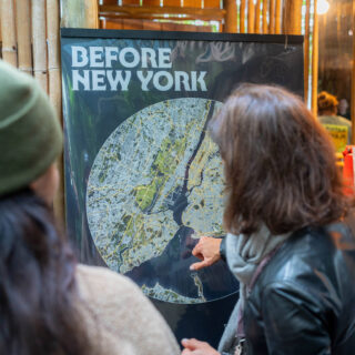 Two people point at a standing map