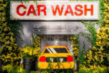A yellow taxi cab in a car wash, rendered in colorful flowers