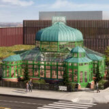 A bright green glass conservatory on a city street