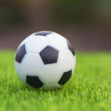 A black and white soccer ball on a green field