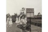 People in white nurses' outfits garden in this black and white photo