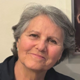 A person with short gray hair poses for a photo