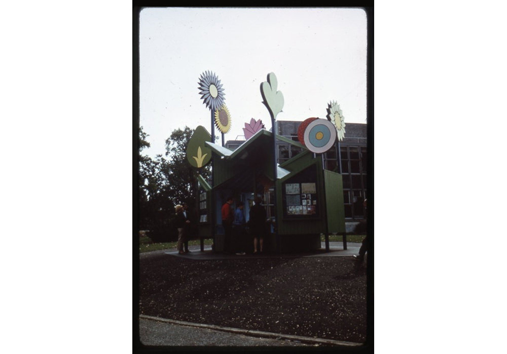 A kiosk covered in tall flower sculptures