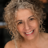 A person with curly hair poses for a photo