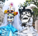 A pair of colorful skeleton puppets wearing festive hats