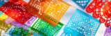 Orange, red, purple, green, and blue flags wave under a sunny sky